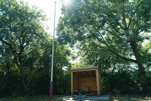 Det overdækkede bålsted i hjørnet af haven.
