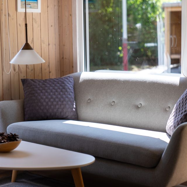 Udestuen med sofa og store vinduer ud mod haven
